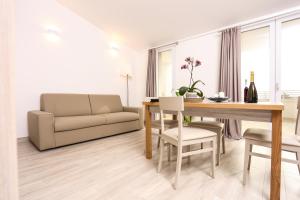 salon ze stołem i kanapą w obiekcie Alma di Alghero Apartments w mieście Alghero