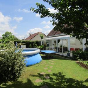 einen Hinterhof mit einer Tischtennisplatte und einem Haus in der Unterkunft au jardin Fessard in Fagnon