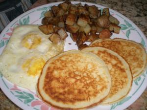 a plate of breakfast food with eggs and potatoes at Khergiansha in Mestia
