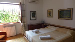 una camera da letto con un letto con due asciugamani sopra di B&B VILLA ELISA a Quartu SantʼElena