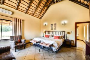a bedroom with a bed and a couch at Zebula Golf Estate & Spa Executive Holiday Homes in Mabula