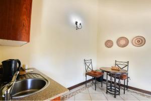a kitchen with a sink and a small table at Zebula Golf Estate & Spa Executive Holiday Homes in Mabula
