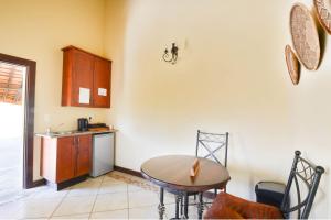 a kitchen with a table and a small kitchen with a sink at Zebula Golf Estate & Spa Executive Holiday Homes in Mabula