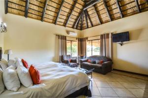 a bedroom with a bed and a living room at Zebula Golf Estate & Spa Executive Holiday Homes in Mabula +37 photos