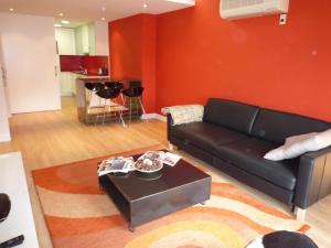 a living room with a black couch and a table at Alizaque Lodge in Cuenca