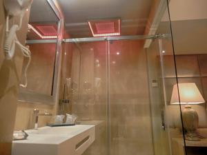 een badkamer met een douche, een wastafel en een spiegel bij Hostal San Andres in Adamuz