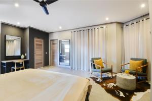 a bedroom with a large bed and two chairs at Zebula Golf Estate & Spa Executive Holiday Homes in Mabula