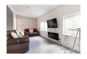 uma sala de estar com um sofá e uma televisão de ecrã plano em treetops flat3 Hall Green B28 em Birmingham
