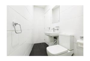 La salle de bains blanche est pourvue de toilettes et d'un lavabo. dans l'établissement treetops flat3 Hall Green B28, à Birmingham