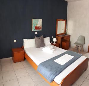 a bedroom with a large bed with a blue wall at Helena Apartments in Paralia Panteleimonos