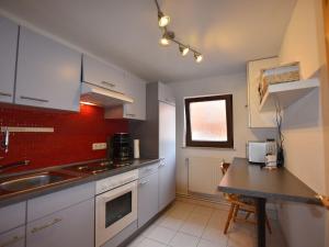 a kitchen with white cabinets and a sink and a counter at Cozy Retreat in Kröpelin in Kröpelin