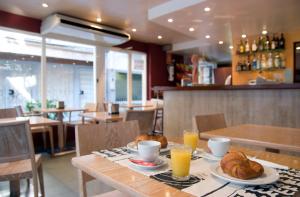 - une table avec deux assiettes de pain et de jus d'orange dans l'établissement Hotel Es Furió, à Tamariu