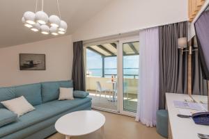 a living room with a blue couch and a table at Apartments Vila 4m in Ražanac
