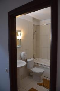 a bathroom with a toilet and a sink at Denis Summer in Mamaia