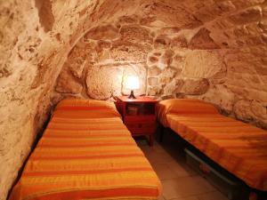 a bedroom with two beds in a stone room at Casa Vacanze Cattedrale in Ostuni