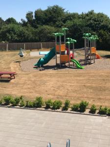 ein Spielplatz mit Rutsche in einem Park in der Unterkunft Bredebro camping in Bredebro