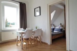 a dining room with a table and chairs and a bed at Meissen Apartments - moderne Ferienwohnungen in Meißen am Lutherplatz in Meißen