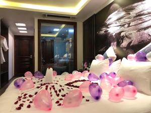 ein Bett mit rosa Ballons und einem Kuchen drauf in der Unterkunft Delta Sapa Hotel in Sa Pa