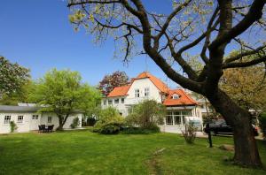 a large white house with an orange roof at Strandvilla Rheingold - Ferienwohnung Da Vinci in Göhren