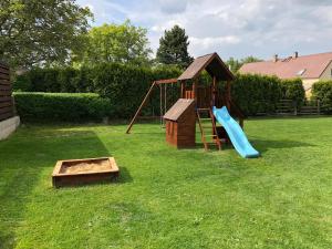 un parque infantil con un tobogán y un juego de juegos en Chata Hluchavka II en Arnoltice u Decina