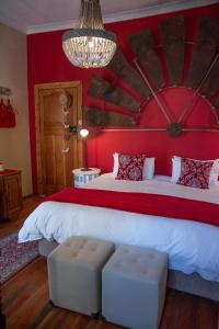 a bedroom with a large bed with red walls at Mirabel Guesthouse in Parys