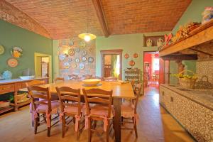 een keuken en eetkamer met een houten tafel en stoelen bij Villa Lorenza by PosarelliVillas in Bucciano