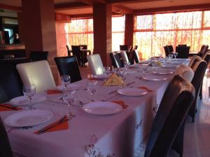 a long table with plates and glasses on it at Pensiunea La Tase in Calafat