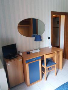 a wooden desk with a laptop and a lamp at Hotel Pineta in Cagli
