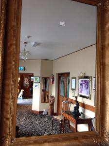 a mirror reflection of a living room with a table at Templemore Arms Hotel in Templemore