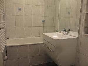 a white bathroom with a sink and a bath tub at Im Zentrum Hebelhof 2 Zi. in Freiburg im Breisgau
