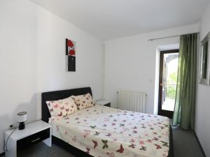 a white bedroom with a bed and a window at Pleasant Apartment in Zidarici near the Sea in Malinska