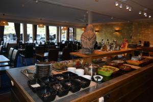 a buffet line with food on a table in a restaurant at Strand Fjordhotel in Ulvik