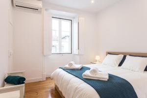 リスボンにあるThree bedroom apartment in historical centre -Bairro Altoの白いベッドルーム(大型ベッド、タオル付)