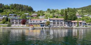 um grupo de edifícios ao lado de uma massa de água em Strand Fjordhotel em Ulvik