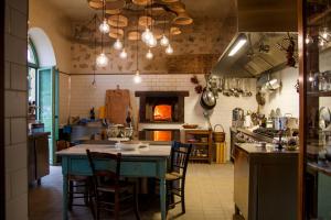 una cucina con tavolo, sedie e piano cottura di Resort Fontes Episcopi ad Aragona