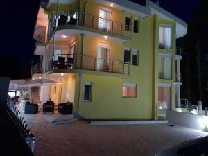a yellow building with a balcony and a patio at Villa Medusa Apartments in Dobra Voda