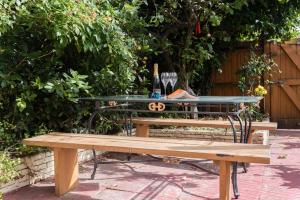 a picnic table and a bench with a bottle of wine at The Nine Elms Residence in London