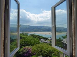 an open window with a view of the water at Bryn Melyn Apartments in Barmouth