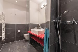 ein Badezimmer mit einem roten Waschbecken und einem WC in der Unterkunft Seeresidenz in Börgerende-Rethwisch