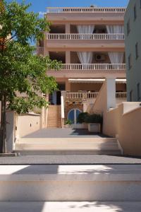 a building with stairs in front of it at Agava Apartments Begic in Makarska