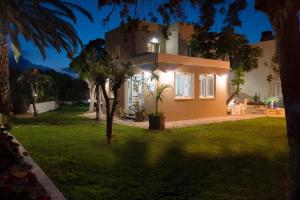 a house with a lit up yard at night at Blue Sky Apartments in Malia