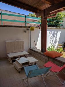 eine Terrasse mit Stühlen, einer Bank und einem Tisch in der Unterkunft Casa Poesia in Torre dell'Orso