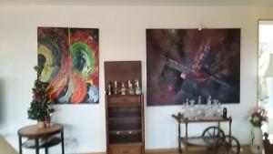 una habitación con dos mesas y dos cuadros en la pared en Villa med sjöutsikt en Immeln