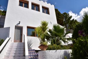 una casa bianca con scale e una palma di Villa Pico a Sella