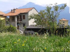 グラヴェドーナにあるCasa Mariaの建物のある家と草原