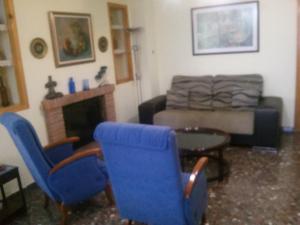 sala de estar con sillas azules y sofá en Casa Fátima Vivienda turística de alquiler rural, en Jaén