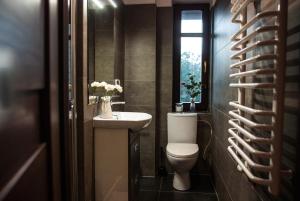 uma casa de banho com um WC, um lavatório e uma janela em Gimnazjalna 5 - Apartamenty i pokoje w Centrum Zakopanego em Zakopane