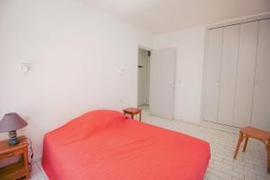カネ・アン・ルシヨンにあるOHANES - 3 pièces vue mer et parkingのキャビネット付きの部屋に赤いベッドが備わるベッドルーム1室があります。