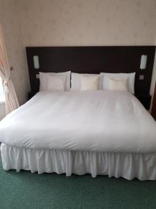 a large white bed with white sheets and pillows at The Hebburn Great House in Hebburn-on-Tyne