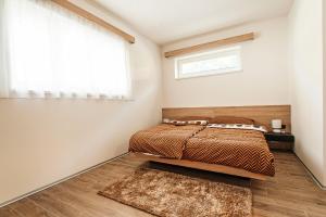 1 dormitorio con cama, ventana y alfombra en The Fox Apartment, en Vrchlabí